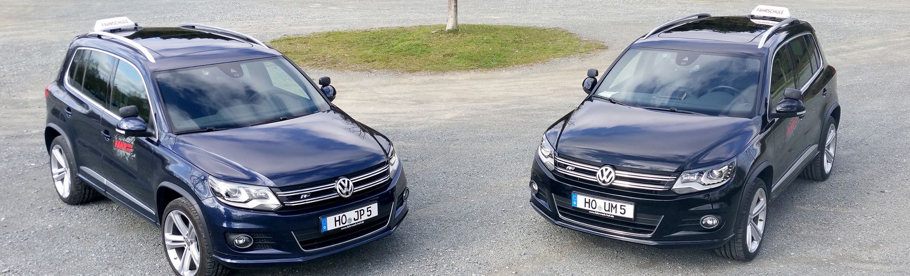 Zwei VW Tiguan der Fahrschule Fahrwerk von vorne